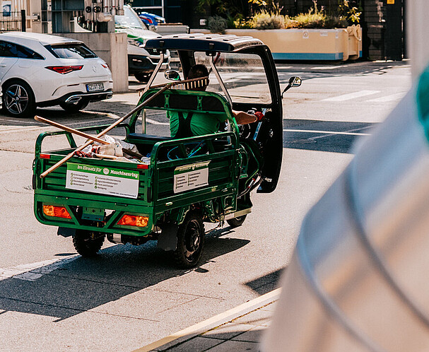 Ein Industriegebiet, in dem ein kleiner grüner Dreirad-Transporter fährt - Betriebsanlagengenehmigung in Wien