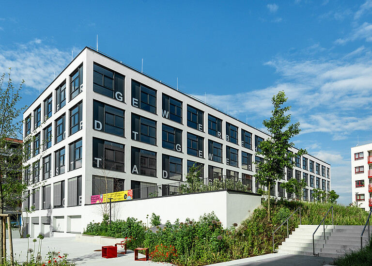 Ein mehrstöckiges Gebäude für Handwerksbetriebe und Produktionsunternehmen von außen.