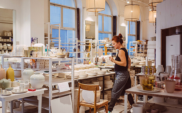 Feinedinge_Porzellan_c_KarinHackl feinedinge: Eine Frau steht in einem Keramikatelier.