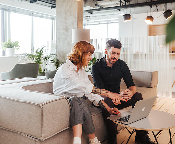 Ein Mann und eine Frau sind im Climate Lab vor einem Laptop im Gespräch
