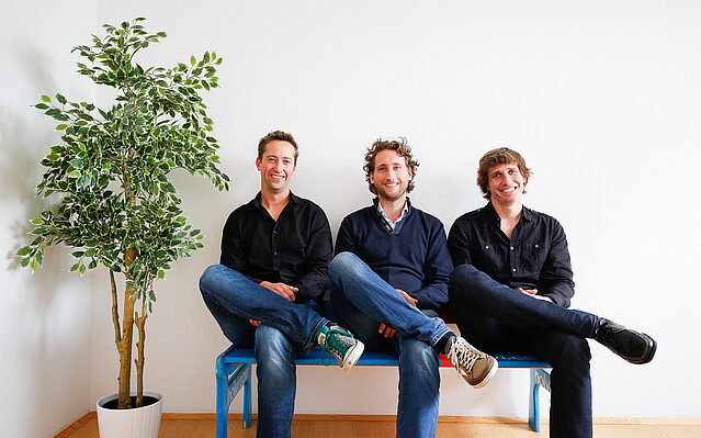 TourRadar: Drei Männer sitzen auf einer Bank.